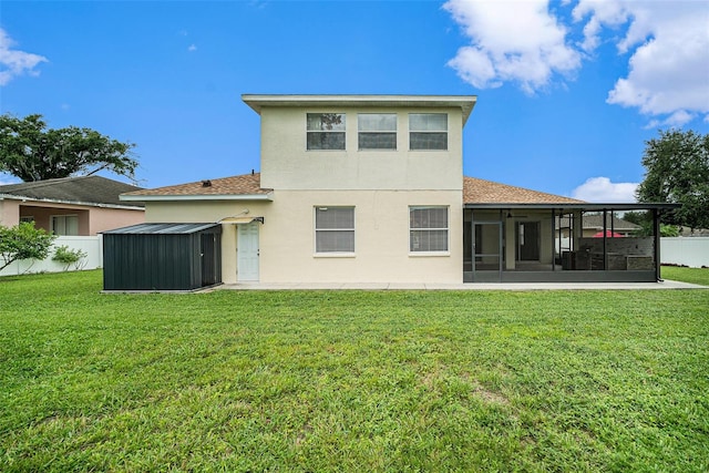 rear view of house featuring a yard and a sunroom