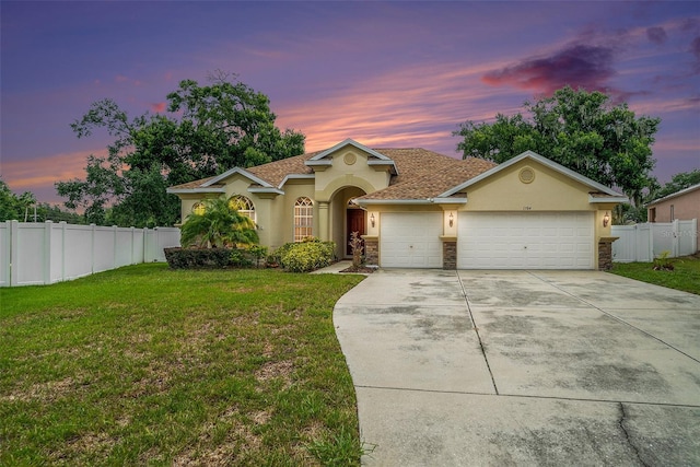 view of front of property with a garage and a yard