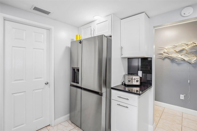 kitchen featuring stainless steel fridge with ice dispenser, white cabinetry, and light tile patterned floors