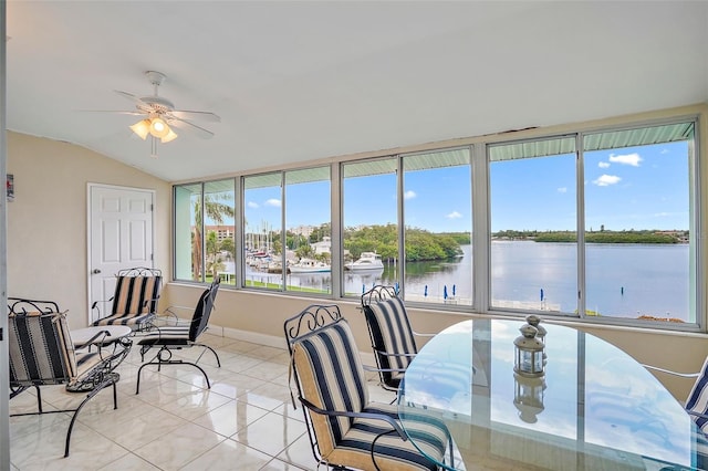 sunroom / solarium featuring a water view, ceiling fan, and vaulted ceiling