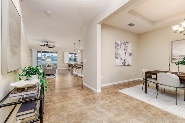 interior space with ceiling fan with notable chandelier