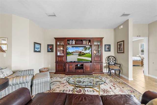 living room with light tile patterned floors and a textured ceiling