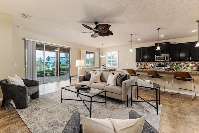 living room featuring a textured ceiling and ceiling fan