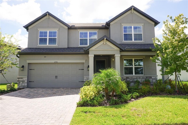 craftsman inspired home featuring an attached garage, stone siding, and stucco siding