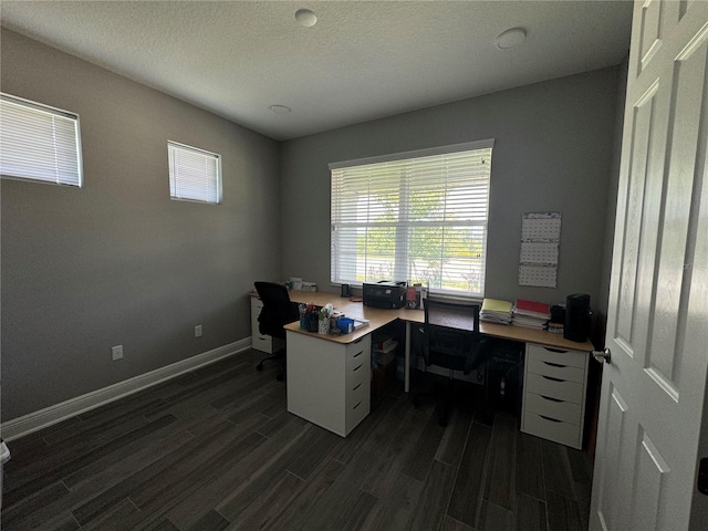 office space with dark wood-style floors, a textured ceiling, and baseboards