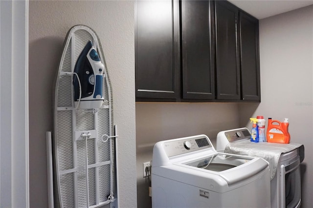 washroom featuring cabinet space and washing machine and dryer