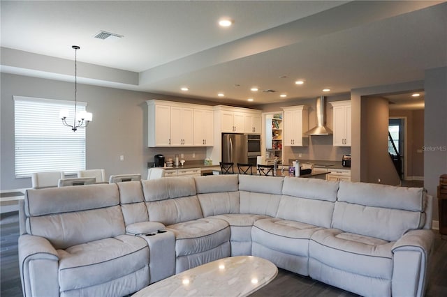 living room featuring recessed lighting, visible vents, and a notable chandelier