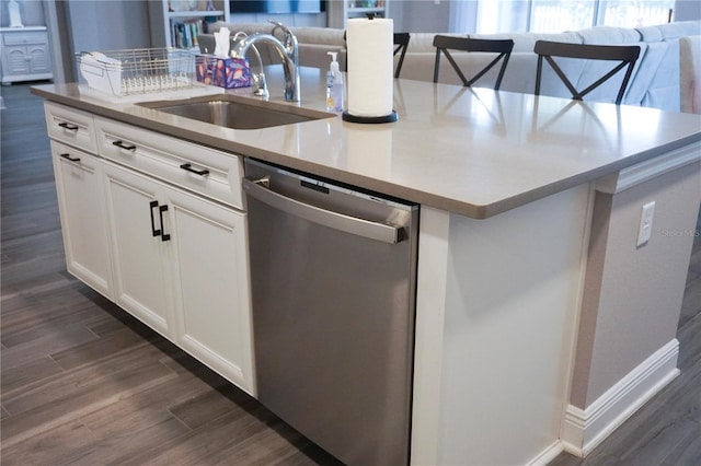 kitchen with dark wood-type flooring, an island with sink, a sink, stainless steel dishwasher, and open floor plan