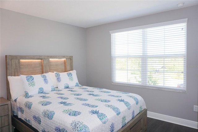 bedroom with dark wood finished floors and baseboards