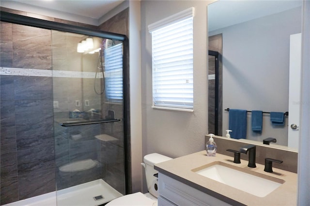 full bath featuring vanity, a shower stall, and toilet