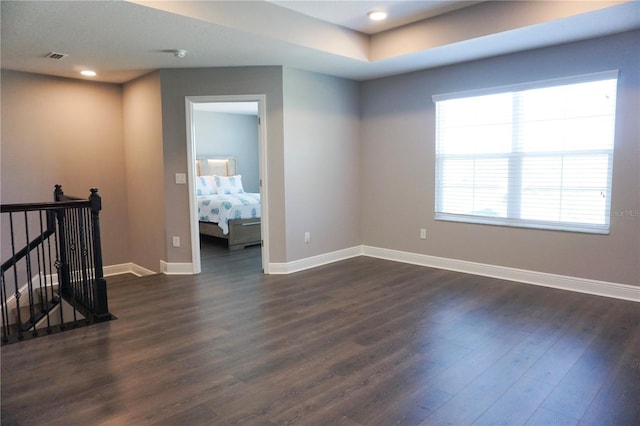 spare room with recessed lighting, visible vents, baseboards, and dark wood-style flooring