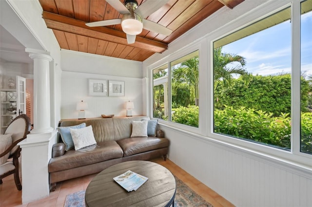 sunroom / solarium featuring beamed ceiling, wooden ceiling, a ceiling fan, and ornate columns