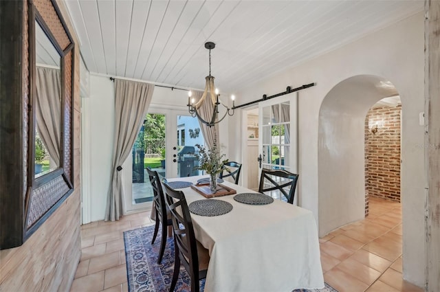 dining area with arched walkways, wood ceiling, an inviting chandelier, and light tile patterned floors