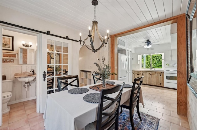 dining space featuring ceiling fan with notable chandelier, wood ceiling, a barn door, and light tile patterned floors