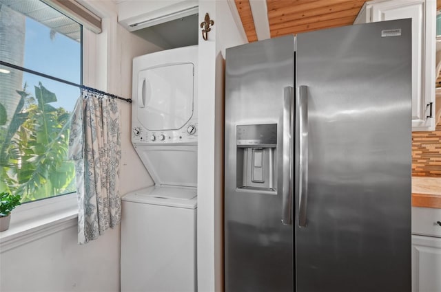 laundry area featuring laundry area, stacked washer / dryer, and a healthy amount of sunlight