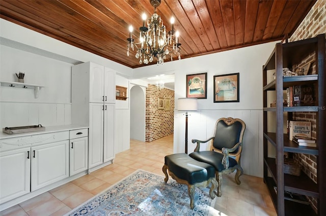 living area featuring arched walkways, wainscoting, wood ceiling, an inviting chandelier, and light tile patterned flooring