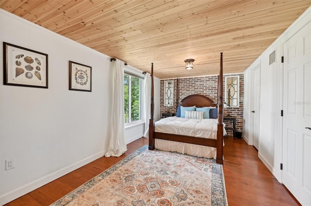 bedroom with visible vents, brick wall, wood finished floors, and wood ceiling