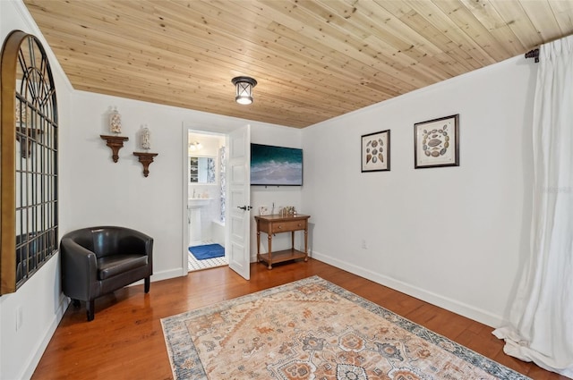 living area featuring wooden ceiling, wood finished floors, and baseboards