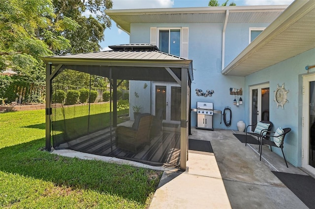 back of house with a lawn, french doors, a standing seam roof, a gazebo, and stucco siding