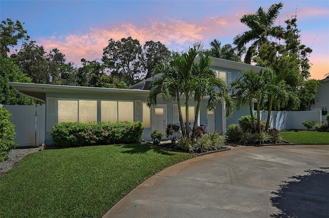 view of front of property featuring a gate, fence, a front lawn, and stucco siding