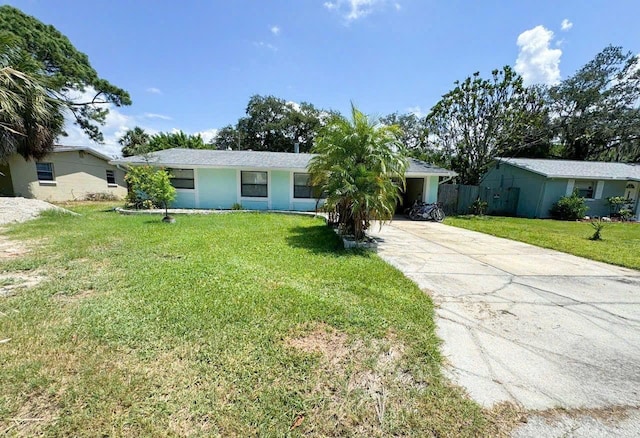 ranch-style home featuring driveway and a front yard