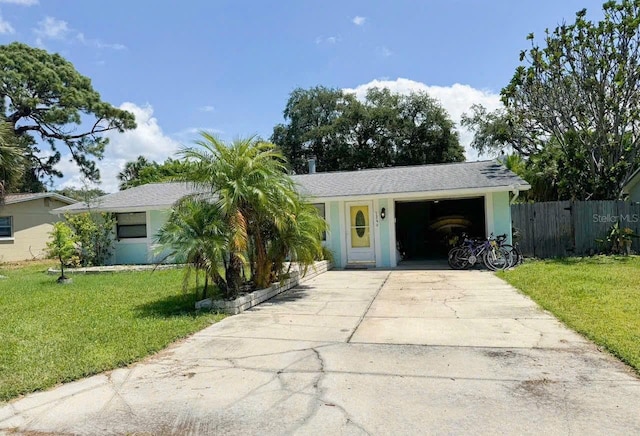 ranch-style home with a garage, fence, driveway, stucco siding, and a front yard