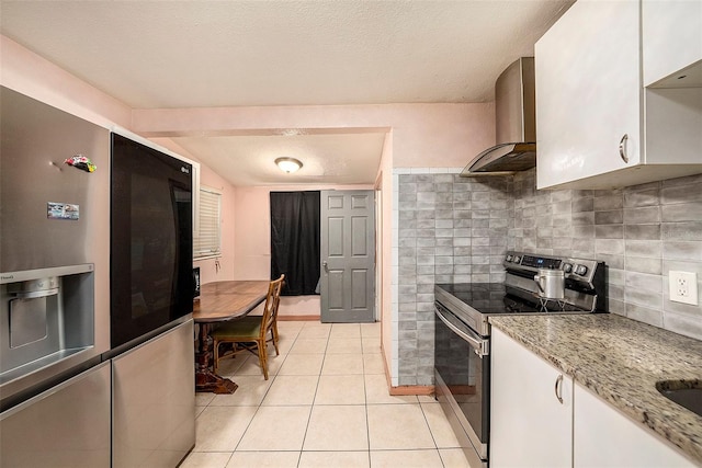 kitchen with wall chimney exhaust hood, appliances with stainless steel finishes, tasteful backsplash, and white cabinets