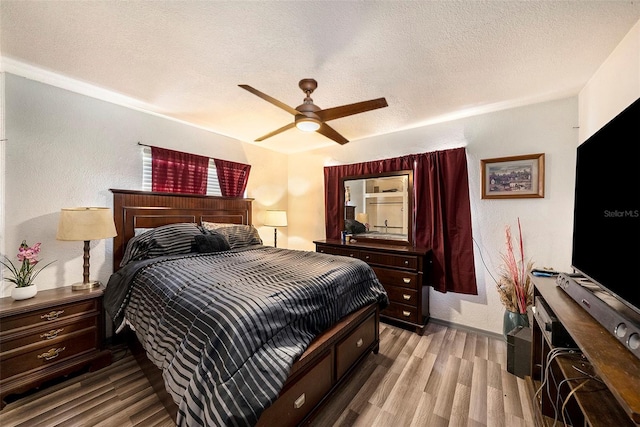 bedroom featuring a textured ceiling, ceiling fan, and hardwood / wood-style flooring