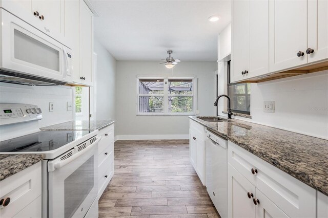 kitchen featuring white appliances, wood-type flooring, sink, ceiling fan, and white cabinets