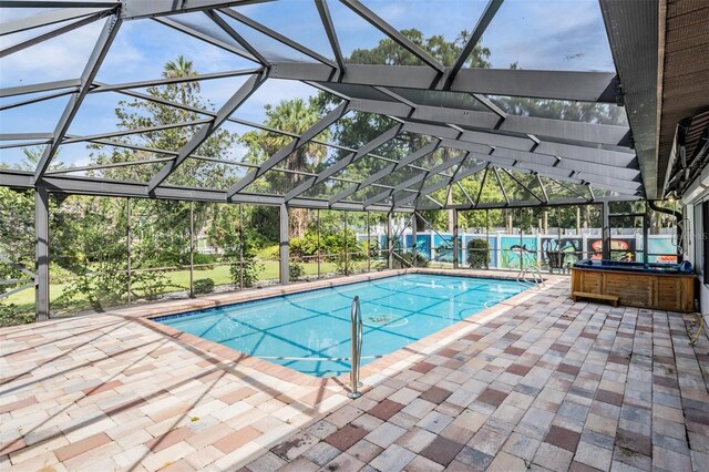 view of swimming pool with a jacuzzi, a patio area, and glass enclosure