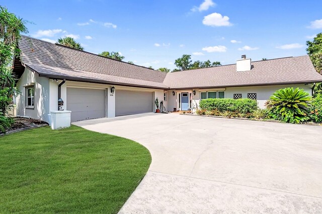 ranch-style home featuring a garage and a front lawn