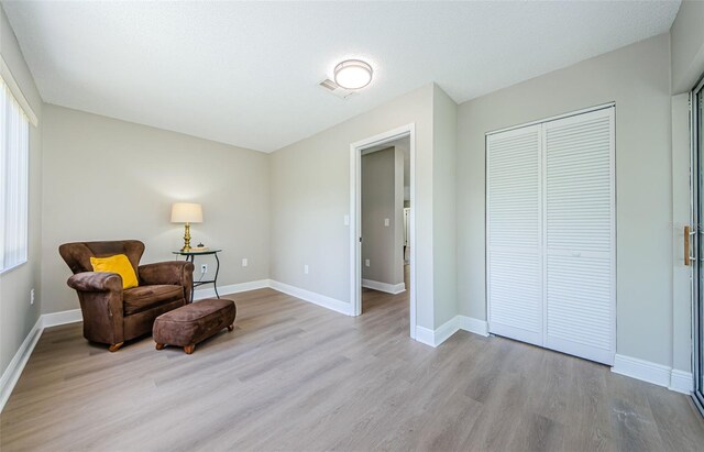 sitting room featuring light wood-type flooring and a textured ceiling