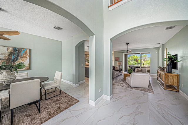 interior space featuring ceiling fan and a textured ceiling