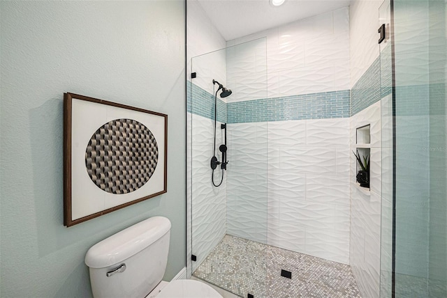 bathroom featuring tiled shower and toilet