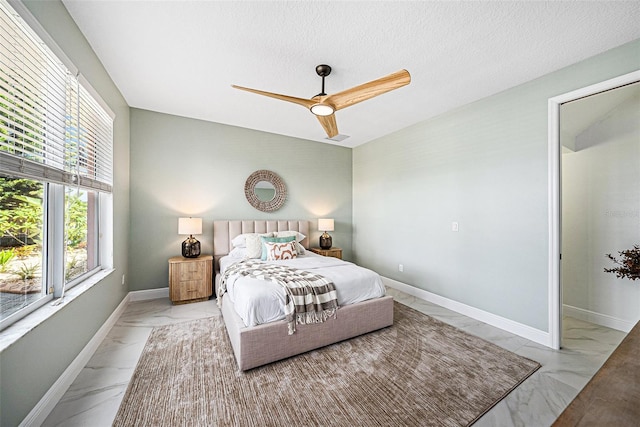 bedroom with ceiling fan and a textured ceiling