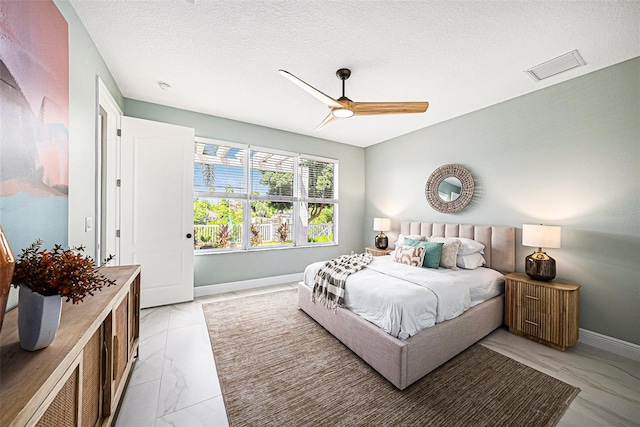 bedroom with a textured ceiling and ceiling fan