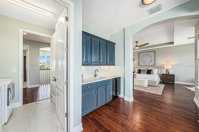 bathroom featuring vanity, ceiling fan, hardwood / wood-style floors, and independent washer and dryer