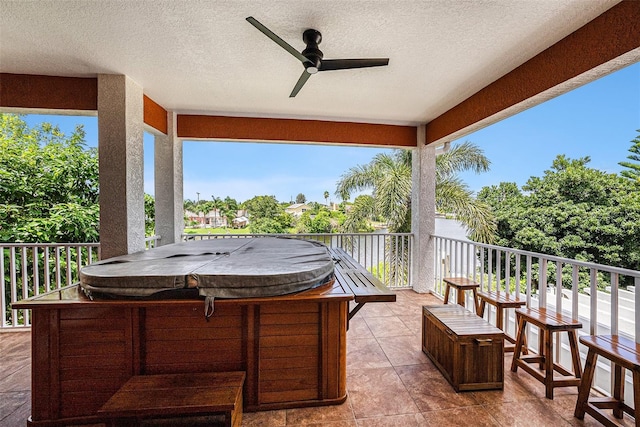 view of patio with ceiling fan and a hot tub