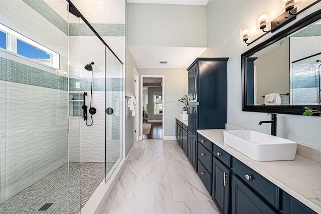 bathroom featuring a shower with shower door and vanity