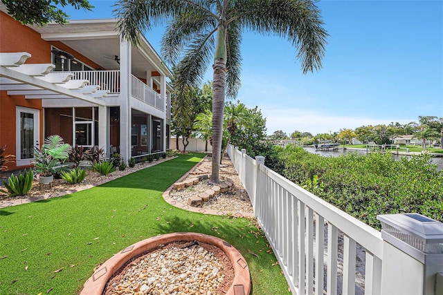 view of yard with a fire pit, a balcony, and a water view