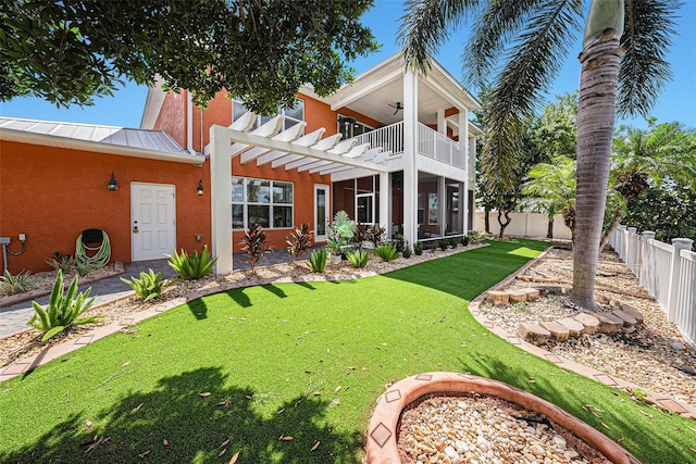 back of property with a balcony, a pergola, a lawn, and a patio area