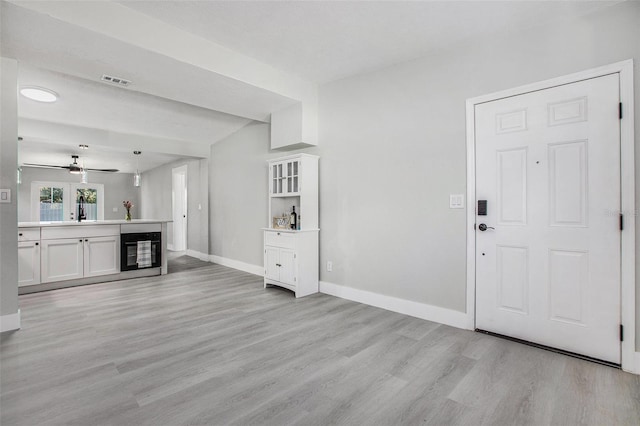 foyer featuring beverage cooler, ceiling fan, light hardwood / wood-style floors, and sink