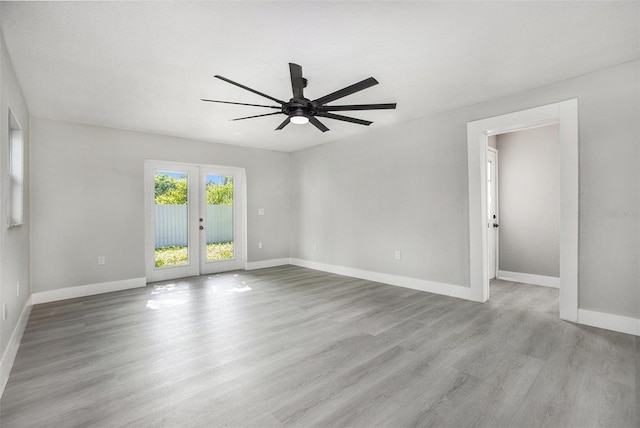 empty room with light hardwood / wood-style flooring, ceiling fan, and french doors