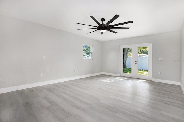 unfurnished room with ceiling fan, light wood-type flooring, and french doors