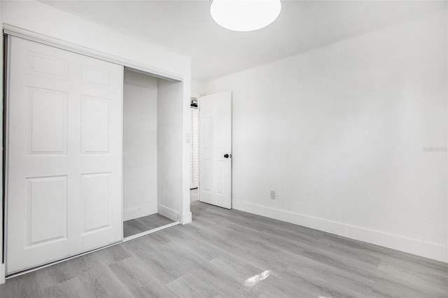 unfurnished bedroom featuring light hardwood / wood-style flooring and a closet