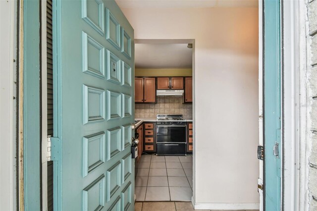 kitchen with gas range oven, decorative backsplash, and light tile patterned flooring