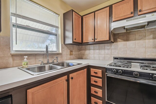 kitchen featuring gas range, sink, and backsplash