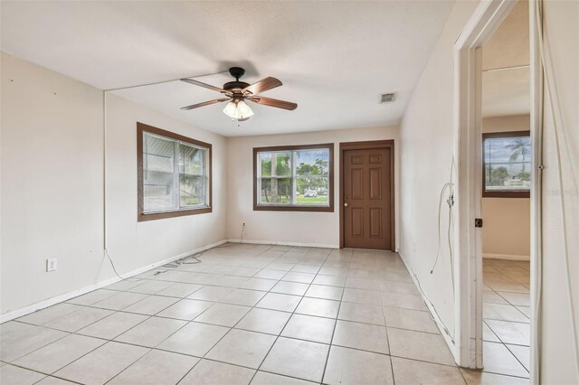 empty room with ceiling fan and light tile patterned floors