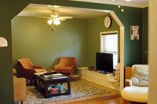 living area with ceiling fan, ornamental molding, and hardwood / wood-style floors