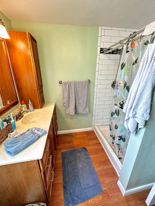 bathroom with vanity, hardwood / wood-style flooring, and walk in shower